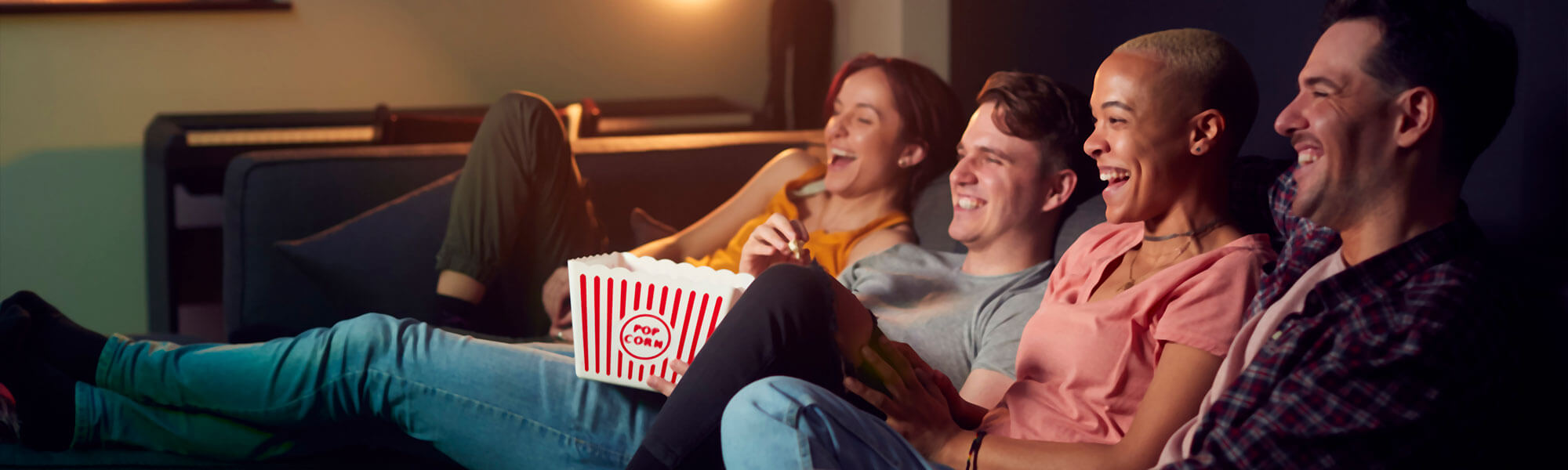 friends watch TV On Demand while snacking on popcorn