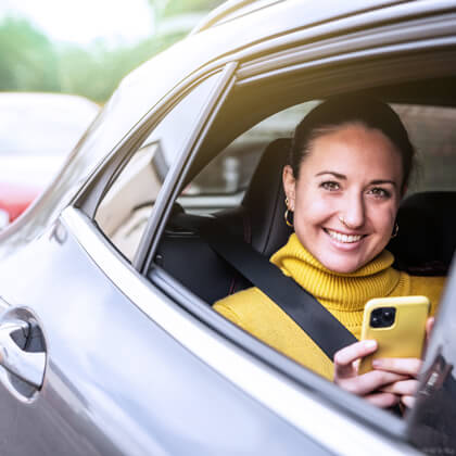 Passenger in a car using her mobile phone.