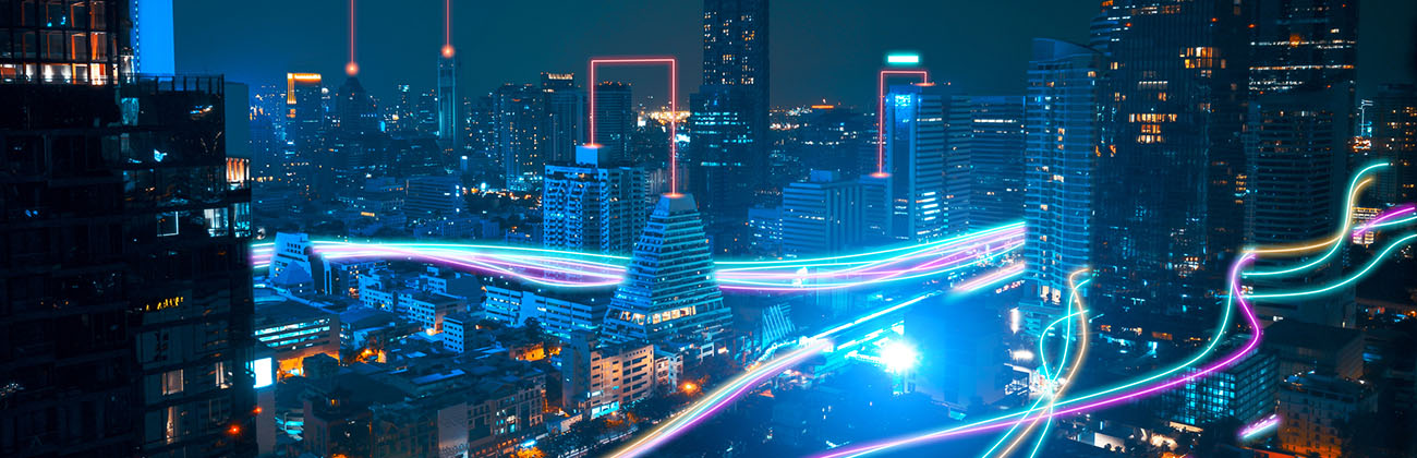 streams of light going through a nighttime city symbolizing the speed of fiber connections