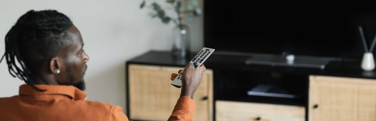 man points remote at a blacked out TV screen during solar interference